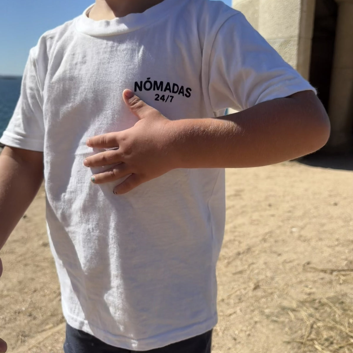 Niño con camiseta Nómadas 24/7 blanca vista frontal